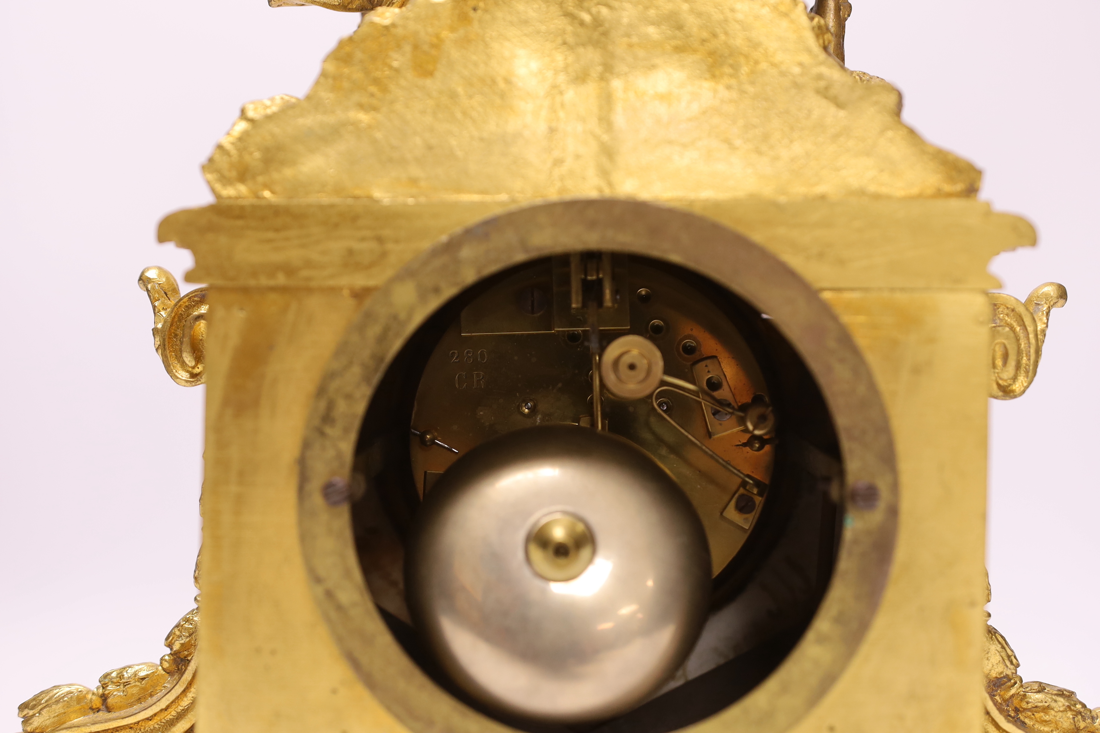 An early 20th century French ormolu mantel clock, with enamel dial, key and pendulum, 31cm